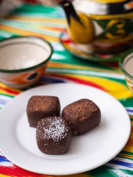 dessert chocolate brownie potatoes in oriental style on a tar with a teapot and a cup for tea. High quality photo