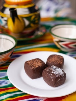 dessert chocolate brownie potatoes in oriental style on a tar with a teapot and a cup for tea. High quality photo