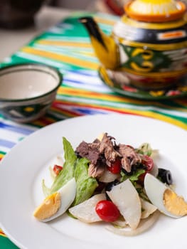 Salad with eggs, herbs, onions, cherry tomatoes, and tuna. Asian style. High quality photo