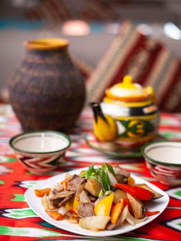 Fried beef meat in oil with potatoes, onions, bell peppers according to the Uyghur recipe. Eastern cuisine, national dish. High quality photo