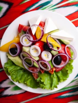 Vegetable slicing in Georgian style - tomatoes, cucumbers, greens, Bulgarian pepper, cheese, onion. Asian style. High quality photo