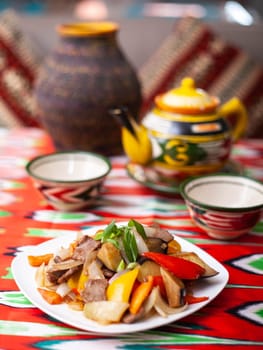 Fried beef meat in oil with potatoes, onions, bell peppers according to the Uyghur recipe. Eastern cuisine, national dish. High quality photo