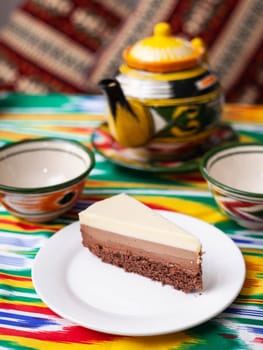 dessert cheesecake three chocolates in an oriental style with a teapot and a cup for tea. High quality photo