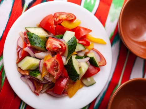 Tomato, cucumber, sweet pepper and onion salad, seasoned with oil. Asian style. High quality photo