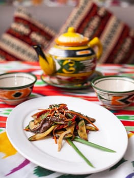 Eastern warm salad. Fried pieces of beef, marcovi and cucumbers in sauce and sesame seeds. Asian style. High quality photo