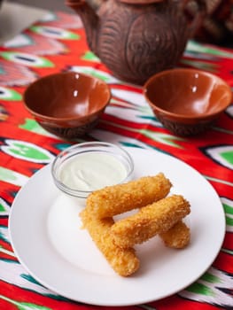 cheese sticks - fried breaded cheese served with creamy sauce. Asian style. High quality photo