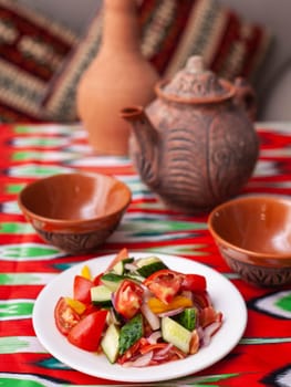 Tomato, cucumber, sweet pepper and onion salad, seasoned with oil. Asian style. High quality photo