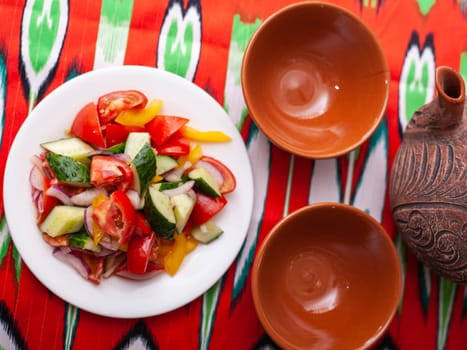 Tomato, cucumber, sweet pepper and onion salad, seasoned with oil. Asian style. High quality photo