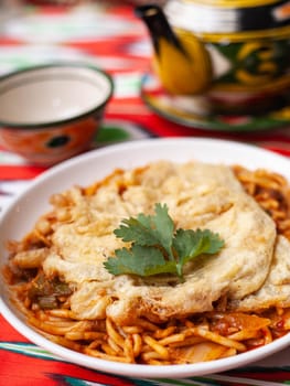 The oriental lagman dish is homemade noodles fried with meat, vegetables and herbs. Eastern cuisine. High quality photo