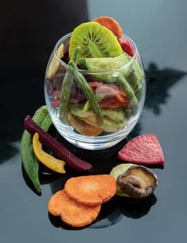 Different colorful dried fruits and vegetables in the glass. Crispy mixed veggies and fruits, Healthy snacks food, Copy space, Selective focus.
