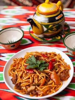 The oriental lagman dish is homemade noodles fried with meat, vegetables and herbs. Eastern cuisine. High quality photo