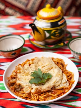 The oriental lagman dish is homemade noodles fried with meat, vegetables and herbs. Eastern cuisine. High quality photo