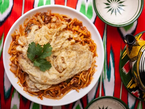 The oriental lagman dish is homemade noodles fried with meat, vegetables and herbs. Eastern cuisine. High quality photo