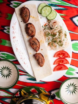 Chicken ifoksr - charcoal grilled chicken breast. Served with vegetables, pickled onions, lavash bread and oriental sauce. Eastern cuisine. High quality photo