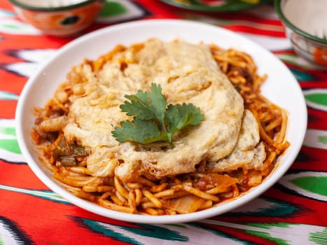 The oriental lagman dish is homemade noodles fried with meat, vegetables and herbs. Eastern cuisine. High quality photo