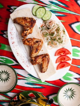 Chicken ifoksr - charcoal grilled chicken breast. Served with vegetables, pickled onions, lavash bread and oriental sauce. Eastern cuisine. High quality photo