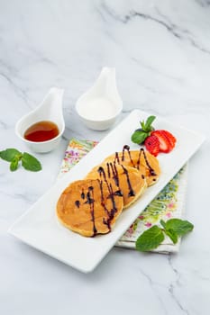 pancakes with chocolate syrup with strawberries