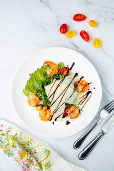 shrimp with avocado slices and arugula