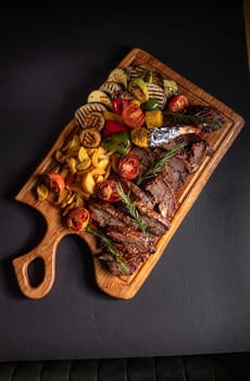 fried pieces of steak with vegetables on the grill