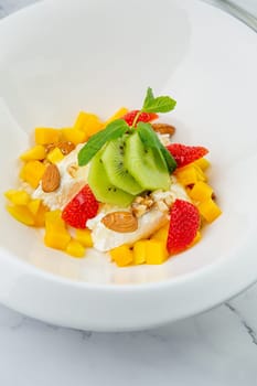 fruit salad with kiwi, strawberries, mango and nuts