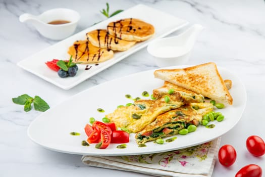 Breakfast of eggs and vegetables with cherry tomatoes and slices of bread