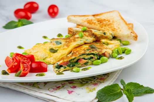 Breakfast of eggs and vegetables with cherry tomatoes and slices of bread
