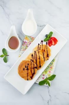 pancakes with chocolate syrup with strawberries