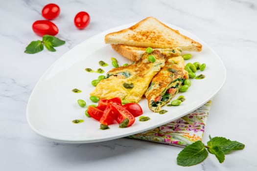 Breakfast of eggs and vegetables with cherry tomatoes and slices of bread