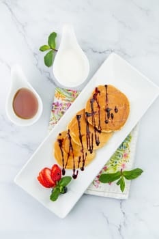 pancakes with chocolate syrup with strawberries