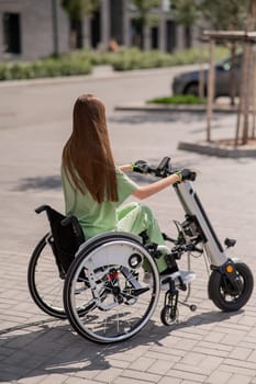 A woman in a wheelchair with an assistive device for manual control. Electric handbike