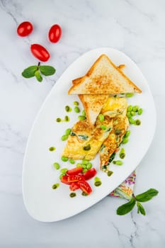 Breakfast of eggs and vegetables with cherry tomatoes and slices of bread