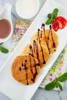 pancakes with chocolate syrup with strawberries