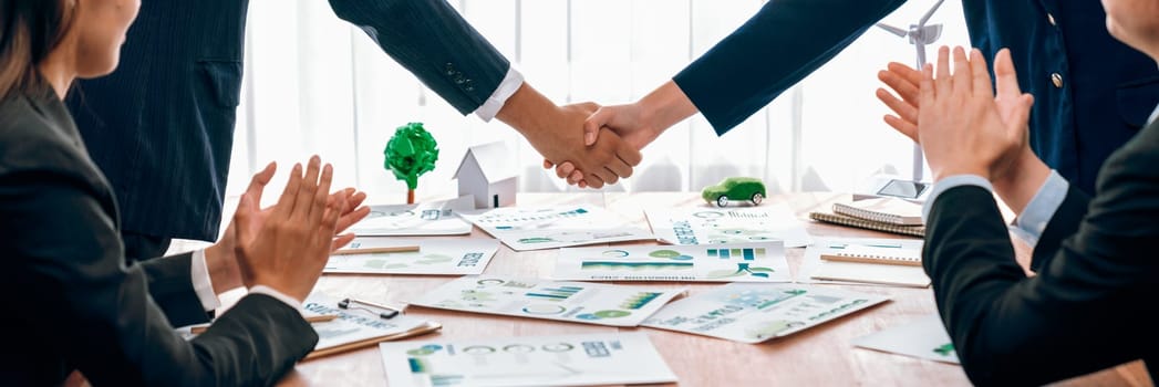 Business people hand shake in Eco corporate meeting room after made successful agreement deal on eco-friendly products. Sustainability and environmental protection in business cooperation.Trailblazing