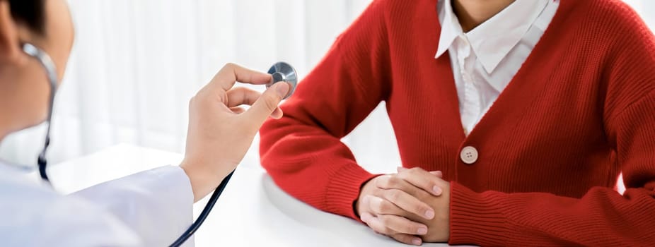 Patient attend doctor's appointment at clinic or hospital office. Doctor examining and diagnosis symptoms while checking the patient's pulse with stethoscope. Panorama Rigid