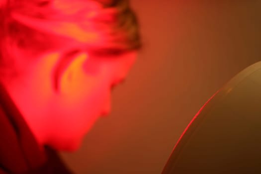 Young woman is irradiated by red light
