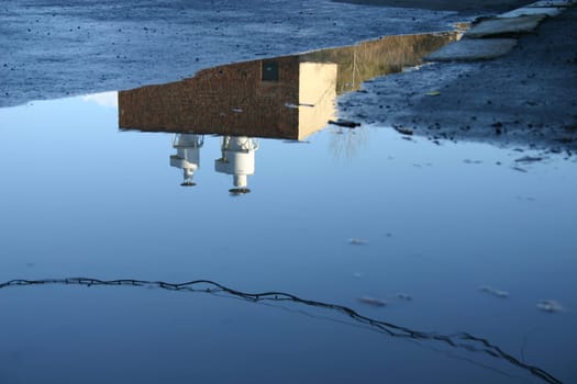 Building reflecting in puddle of water