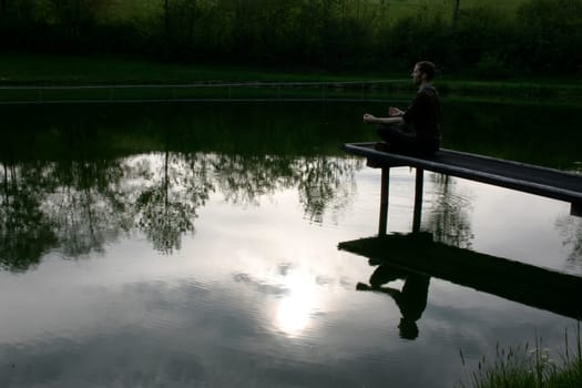 Man sitting on jetty in the evening sun