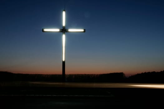 Illuminated cross in the sunset