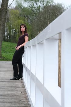 brunette woman leaning against railing