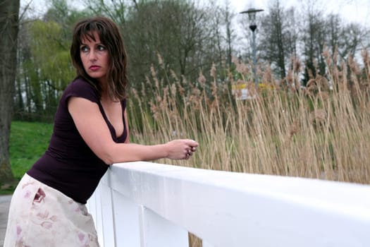brunette woman leaning against railing