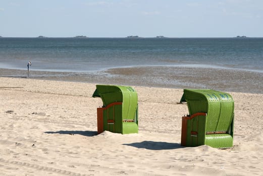 Two in green on the beach of Föhr,in the background the Halligen Langeneß.