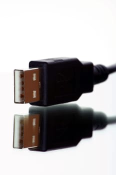 USB plug with cable exposed against white background with mirroring