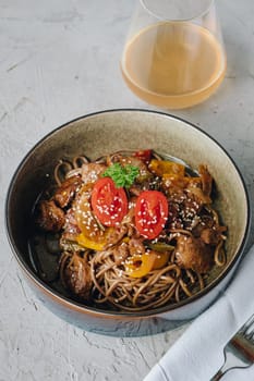 noodles with beef, vegetables, cherry tomatoes and sesame sauce