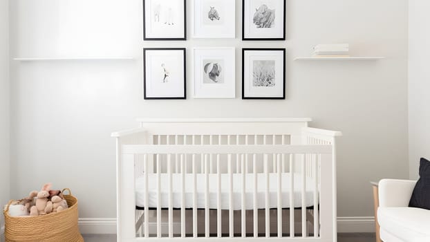 Bright white minimalist nursery wall with frames above cradle. Neural network generated in May 2023. Not based on any actual person, scene or pattern.