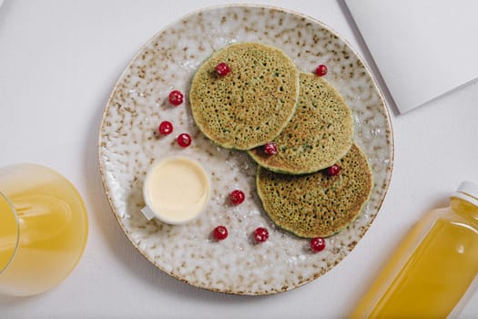 pancakes with berries and cream on a plate