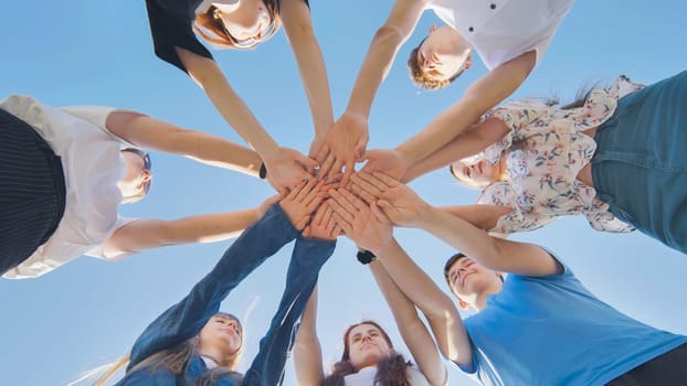 friends putting their hands together in a sign of unity and teamwork