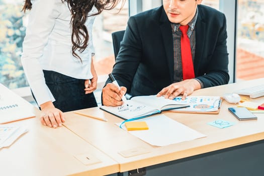 Two business people talk project strategy at office meeting room. Businessman discuss project planning with colleague at modern workplace while having conversation and advice on financial report. Jivy