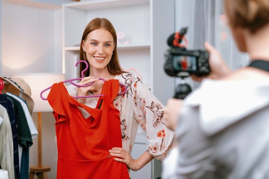 Woman influencer shoot live streaming vlog video review clothes utmost social media or blog. Happy young girl with apparel studio lighting for marketing recording session broadcasting online.