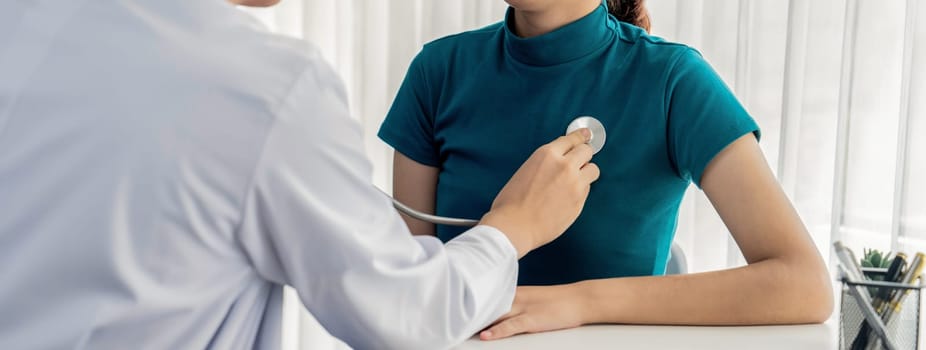 Patient attend doctor's appointment at clinic or hospital office. Doctor examining and diagnosis symptoms while checking the patient's pulse with stethoscope. Panorama Rigid