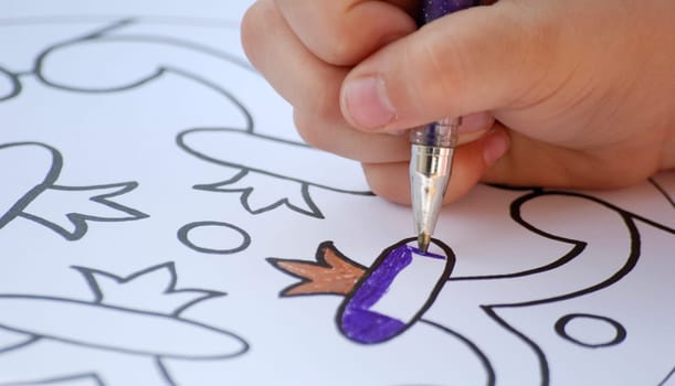 Child paints with crayon